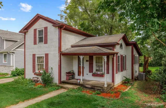 a view of a house with a yard and large tree