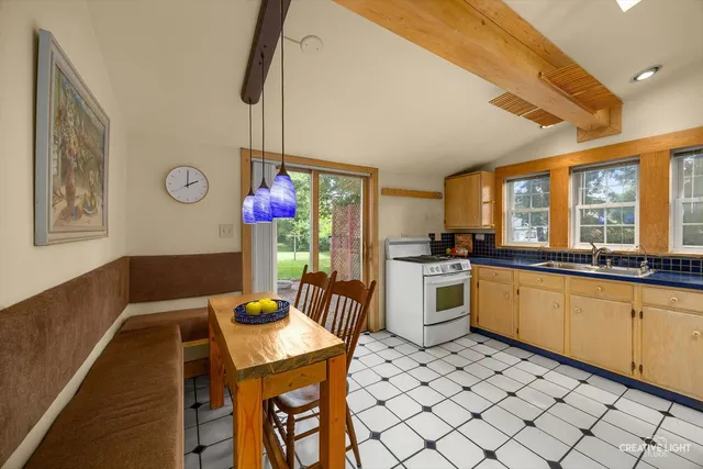 a kitchen with a dining table chairs sink and cabinets