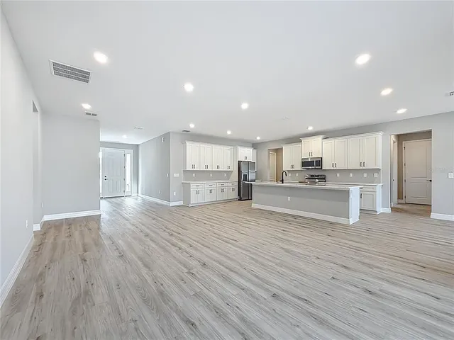 a view of kitchen dining table chairs wooden floor and cabinets