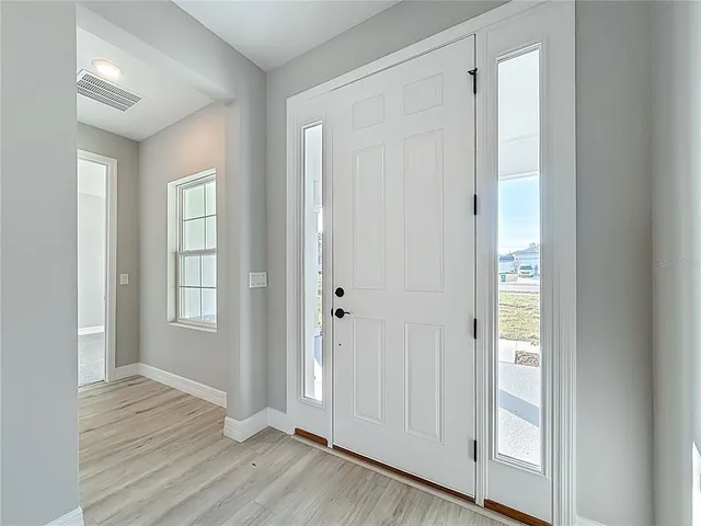 a kitchen with stainless steel appliances white cabinets and wooden floors