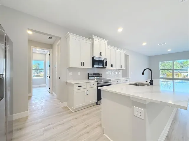 a large white kitchen with a large window