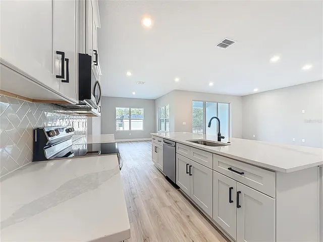 a kitchen with stainless steel appliances a refrigerator sink and cabinets