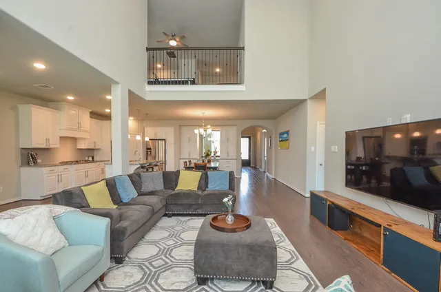a living room with furniture and a view of kitchen