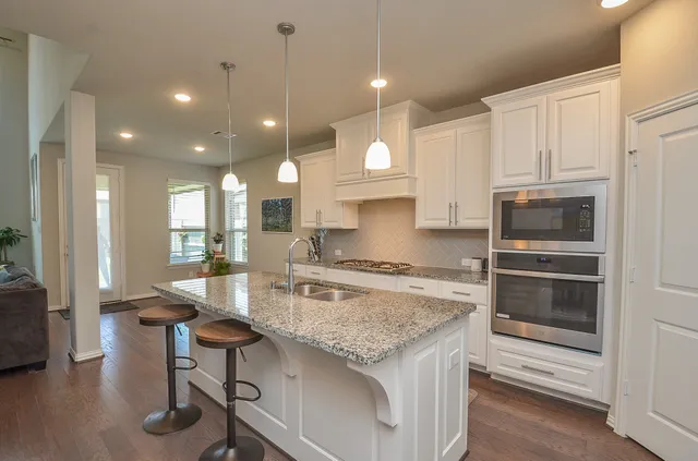 a kitchen with stainless steel appliances granite countertop a stove refrigerator and cabinets