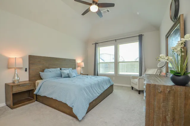a spacious bedroom with a bed and a chandelier