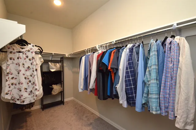 a view of walk in closet with clothes