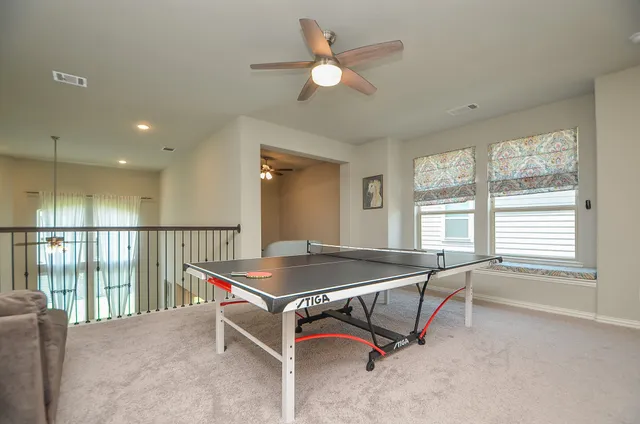 a living room with a table tennis table and a window