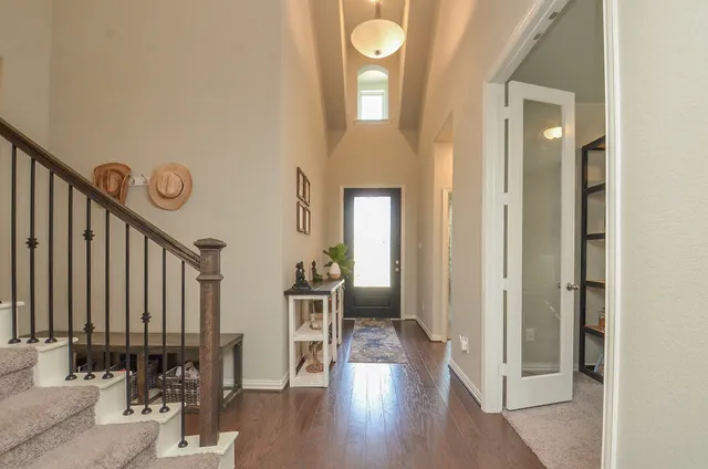 a view of a hallway with wooden floor and a large mirror