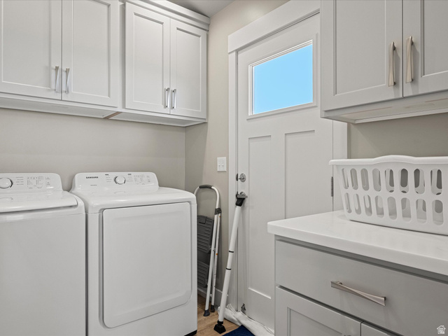 608 Fremont Road Fish Haven, ID 83287 - Photo 20 of 35 Laundry room featuring shaker-style cabinetry with brushed nickel hardware, a solid surface countertop, wood-finish flooring, and a door with an integrated window