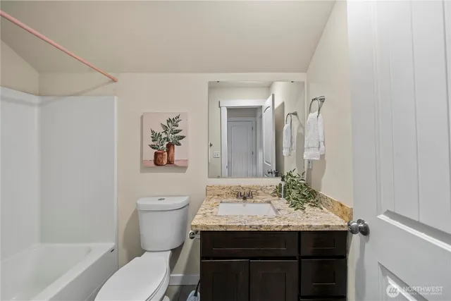 a bathroom with a granite countertop sink a toilet and a bathtub