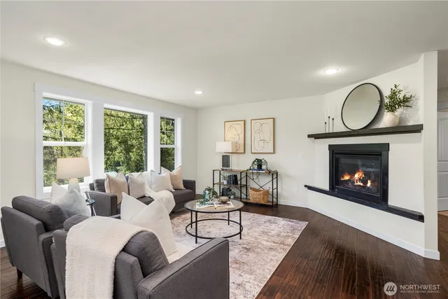 a living room with furniture a fireplace and a floor to ceiling window