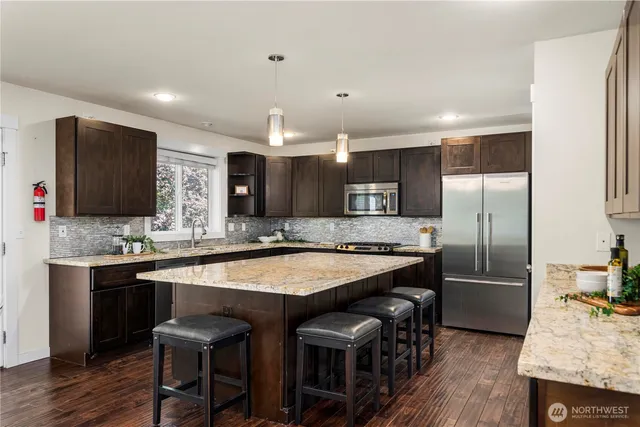 a kitchen with stainless steel appliances granite countertop a sink stove and refrigerator