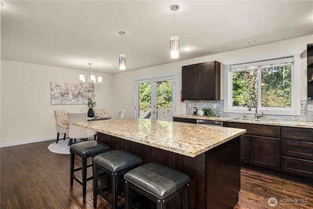 a kitchen with a counter space a sink cabinets and wooden floor