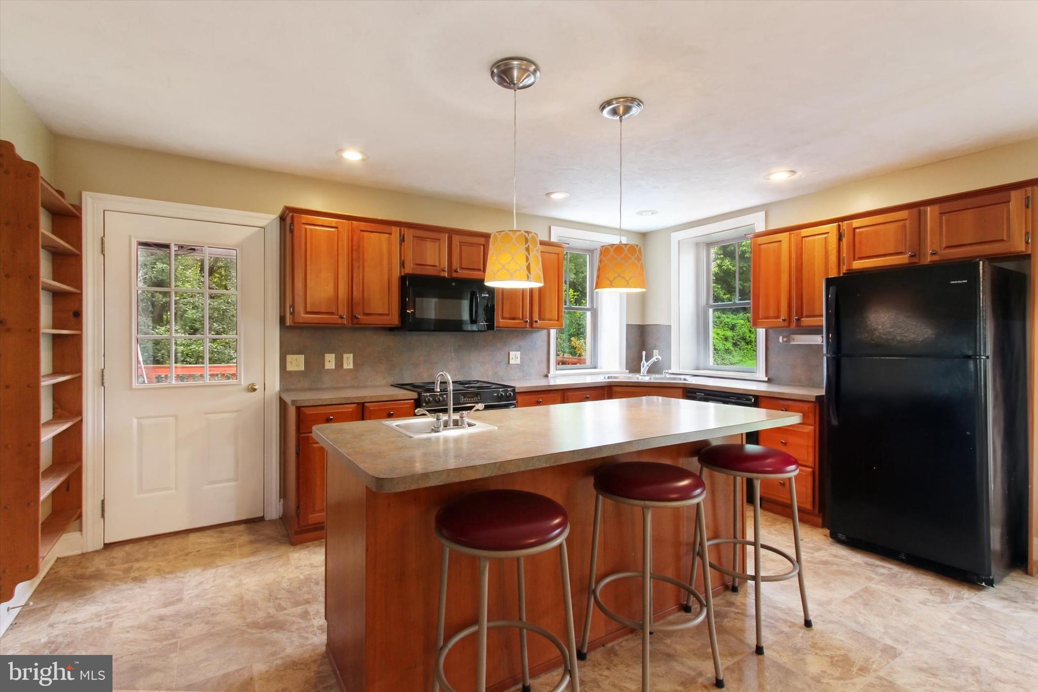 8219 Lehman Road Dallastown, PA 17313 - Photo 18 of 40 a kitchen with stainless steel appliances granite countertop a stove a refrigerator a sink a dining table and chairs with wooden floor