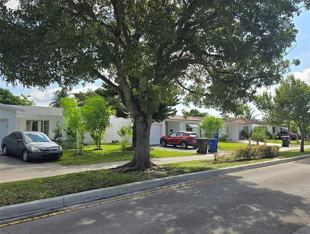 a front view of a house with a garden and trees