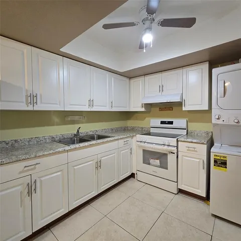a kitchen with granite countertop cabinets stainless steel appliances and a sink