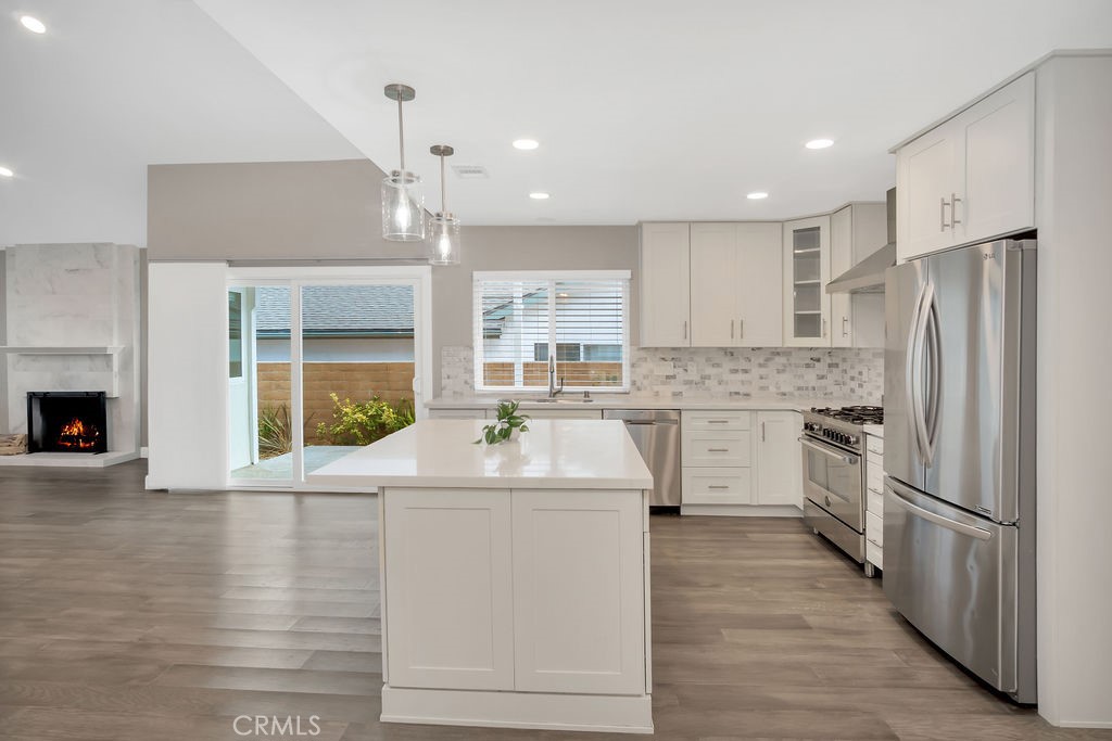 34511 Calle Monte Dana Point, CA 92624 - Photo 31 of 57 a kitchen with kitchen island granite countertop a stove a sink a refrigerator and white cabinets with wooden floor