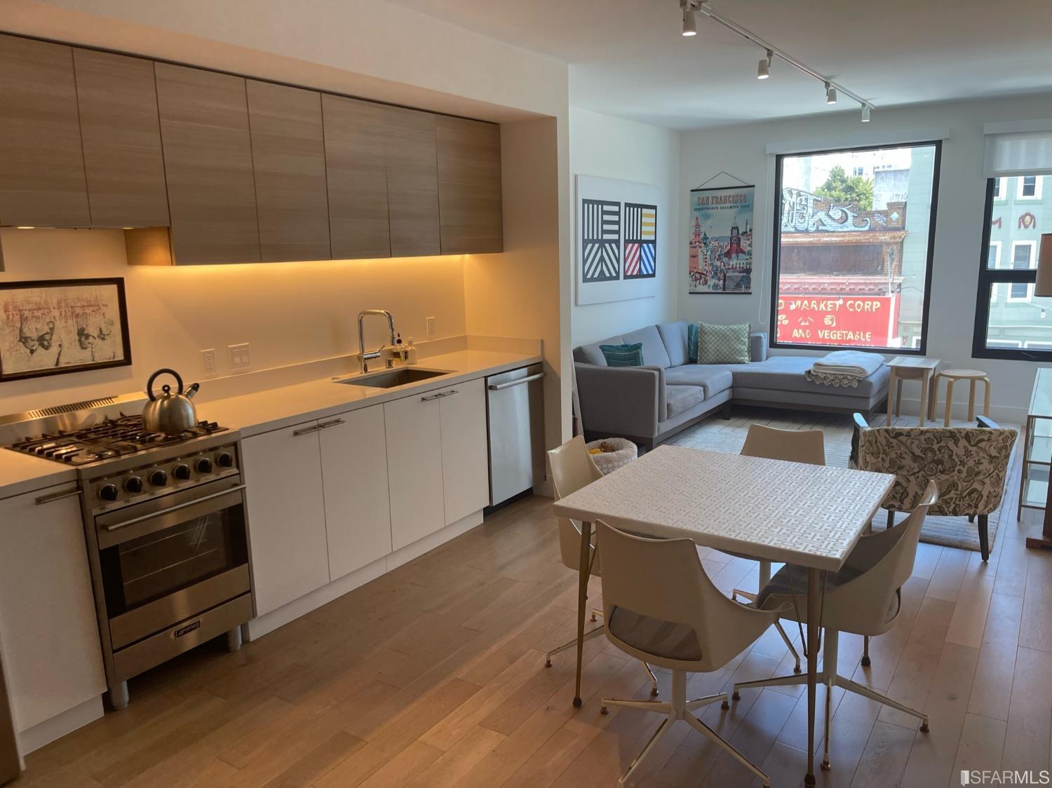 Larkin Street San Francisco, CA 94109 - Photo 7 of 24 a kitchen with stainless steel appliances a stove a table and chairs