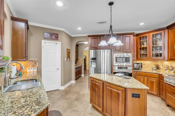 a large kitchen with kitchen island granite countertop a sink and a large window