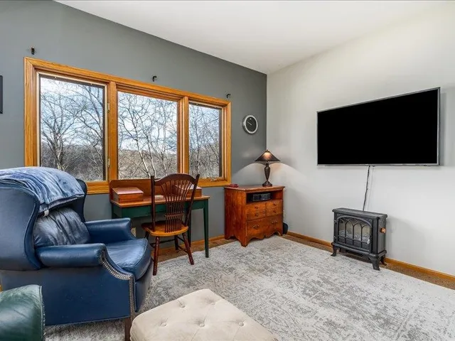 a bedroom with a large bed and a flat tv screen on dresser
