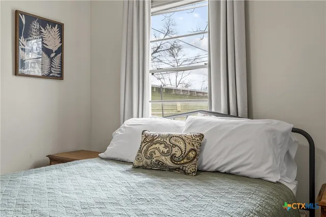 a large bed sitting in a bedroom next to a window