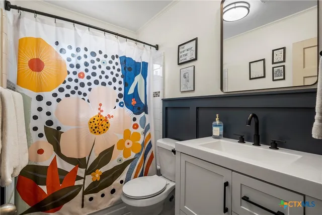a bathroom with a sink mirror vanity and toilet
