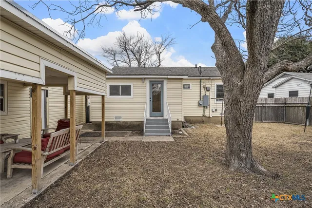 a view of house with backyard and trees
