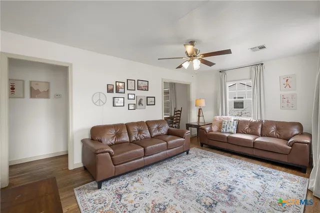 a living room with furniture and a ceiling fan