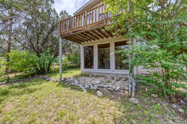 a view of a house with a small yard and a large tree