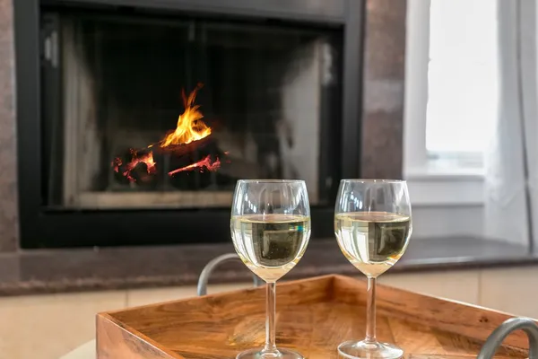 a bottle of wine and a glass of wine sitting near a window