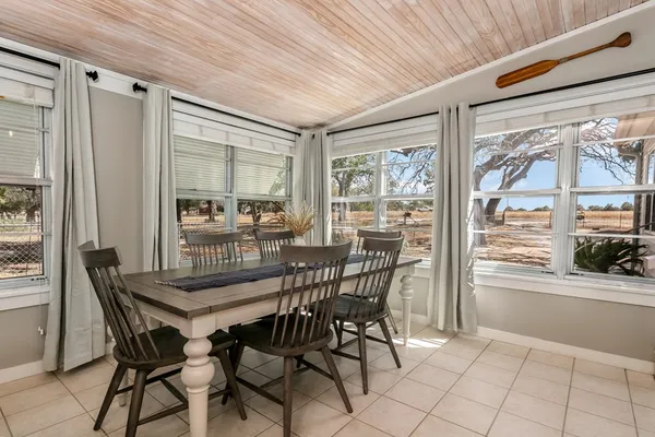 a dining room with furniture and large windows