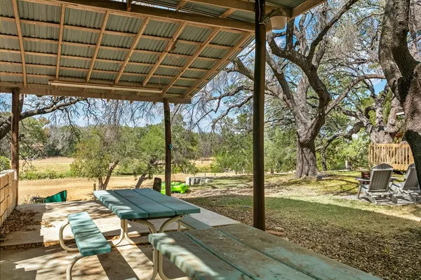 a backyard of a house with barbeque oven table and chairs