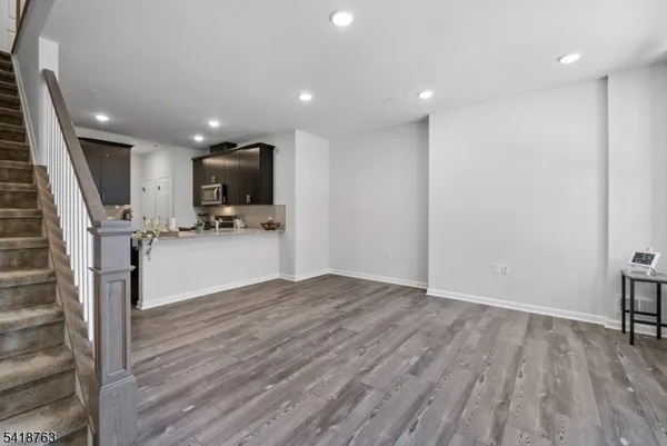 a view of kitchen with refrigerator microwave and wooden floor