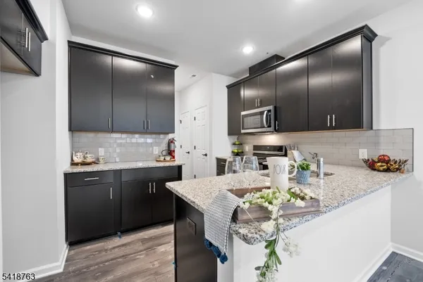 a kitchen with granite countertop stainless steel appliances a sink stove and refrigerator