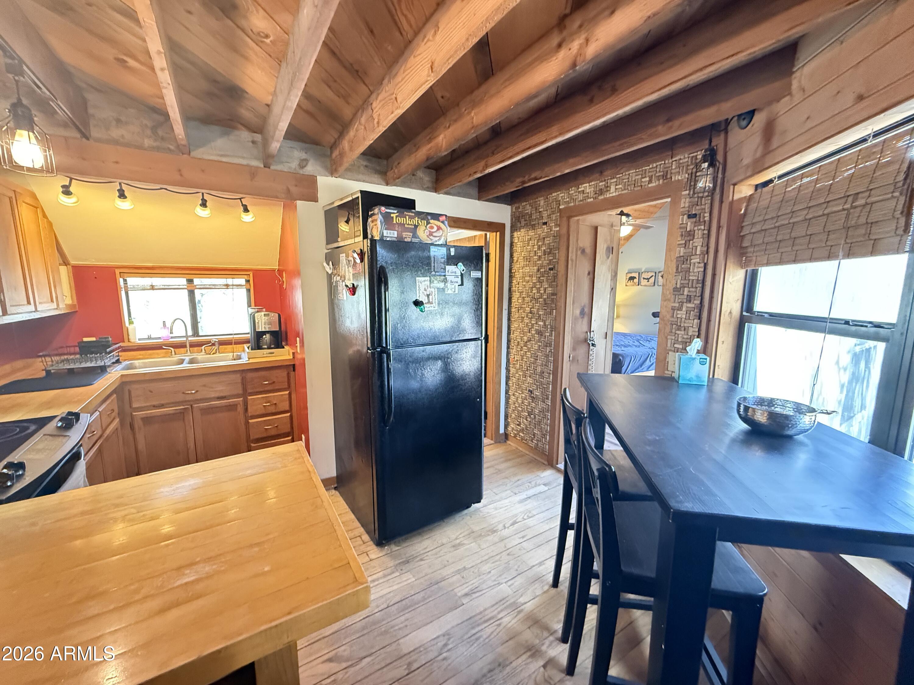 6687 Mountain View Road Crown King, AZ 86343 - Photo 11 of 18 a kitchen with stainless steel appliances wooden floors a table and chairs