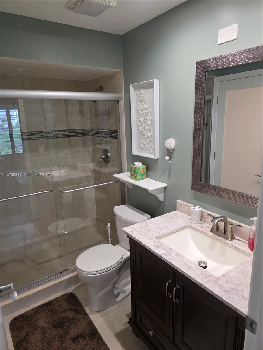 1365 Crystal Way, Unit G Delray Beach, FL 33444 - Photo 12 of 30 a bathroom with a sink a toilet and shower