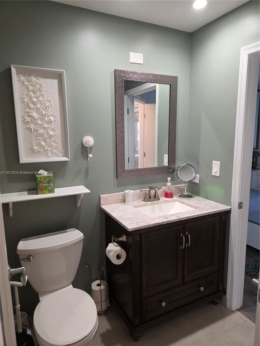 1365 Crystal Way, Unit G Delray Beach, FL 33444 - Photo 13 of 30 a bathroom with a toilet sink and mirror