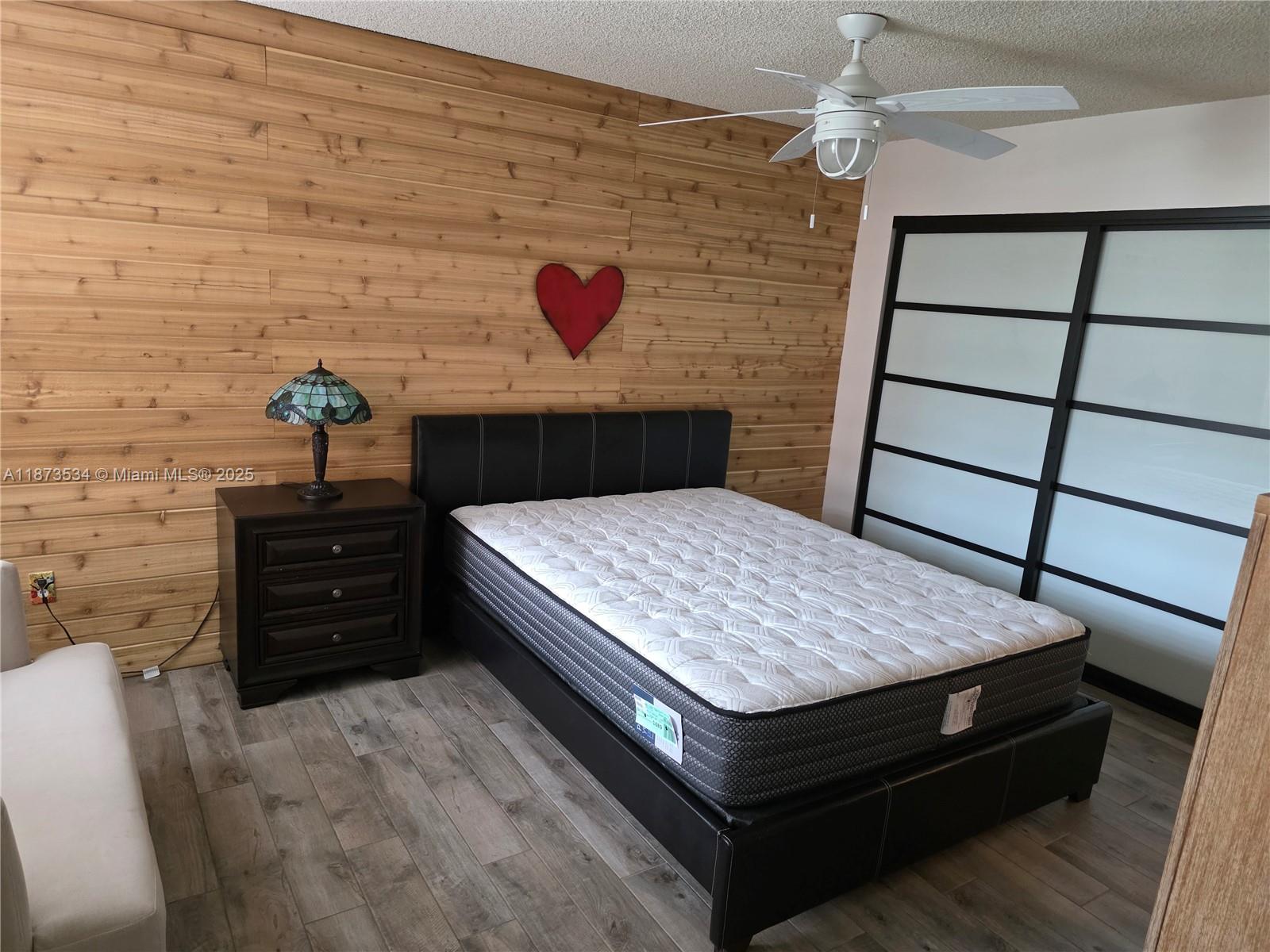 1365 Crystal Way, Unit G Delray Beach, FL 33444 - Photo 17 of 30 a bed sitting in a bedroom next to a cabinet