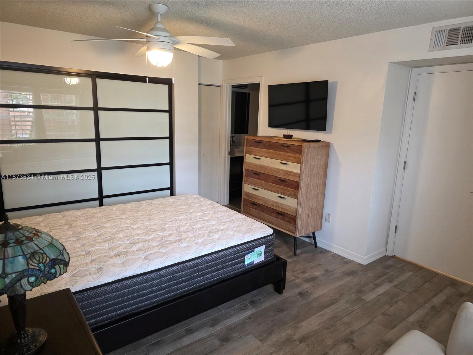 1365 Crystal Way, Unit G Delray Beach, FL 33444 - Photo 20 of 30 a bedroom with a bed and a flat screen tv