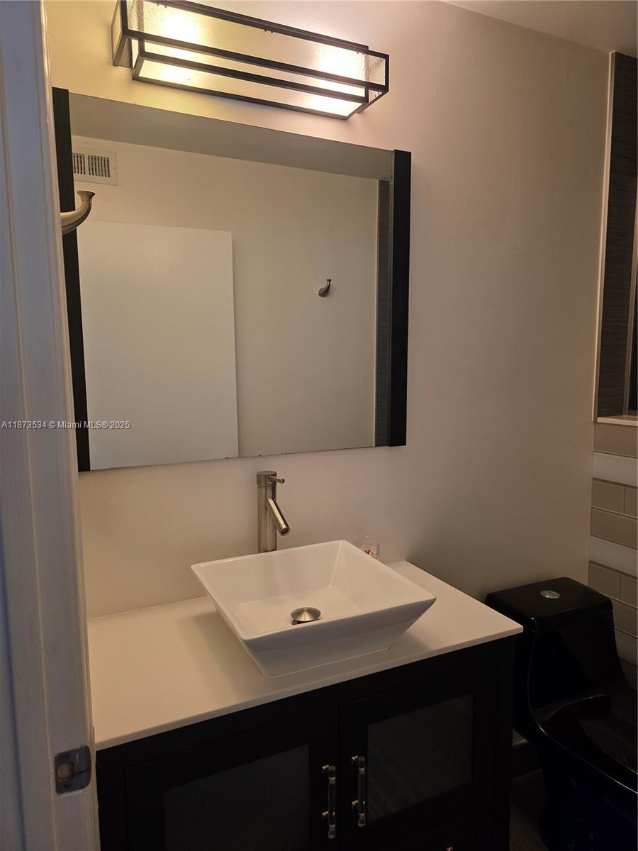 1365 Crystal Way, Unit G Delray Beach, FL 33444 - Photo 21 of 30 a bathroom with a sink and a mirror