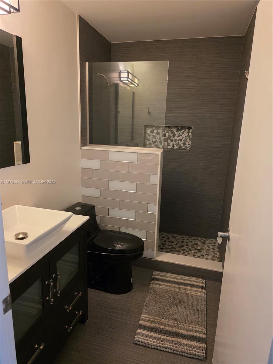 1365 Crystal Way, Unit G Delray Beach, FL 33444 - Photo 22 of 30 a bathroom with a sink and a mirror