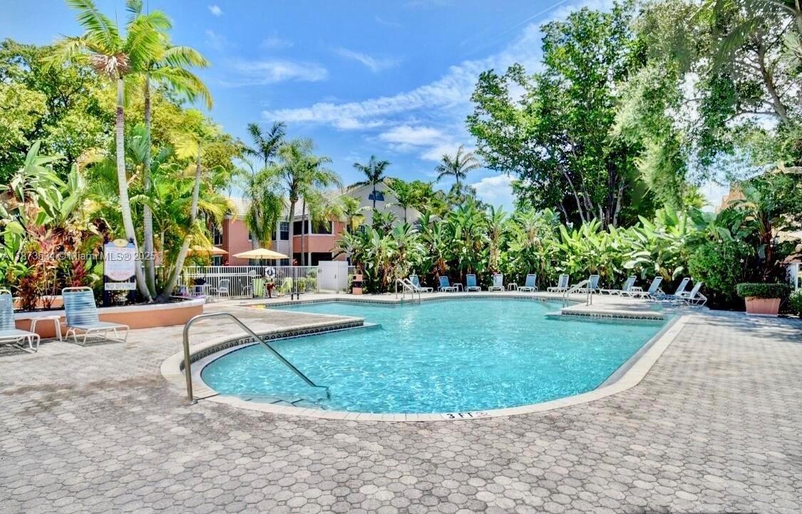 1365 Crystal Way, Unit G Delray Beach, FL 33444 - Photo 28 of 30 a view of a swimming pool with a sitting area