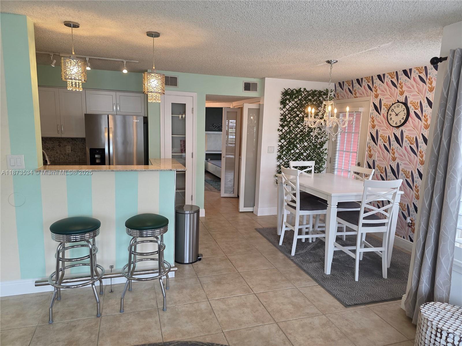 1365 Crystal Way, Unit G Delray Beach, FL 33444 - Photo 3 of 30 a kitchen with stainless steel appliances kitchen island granite countertop dining table chairs and a large window