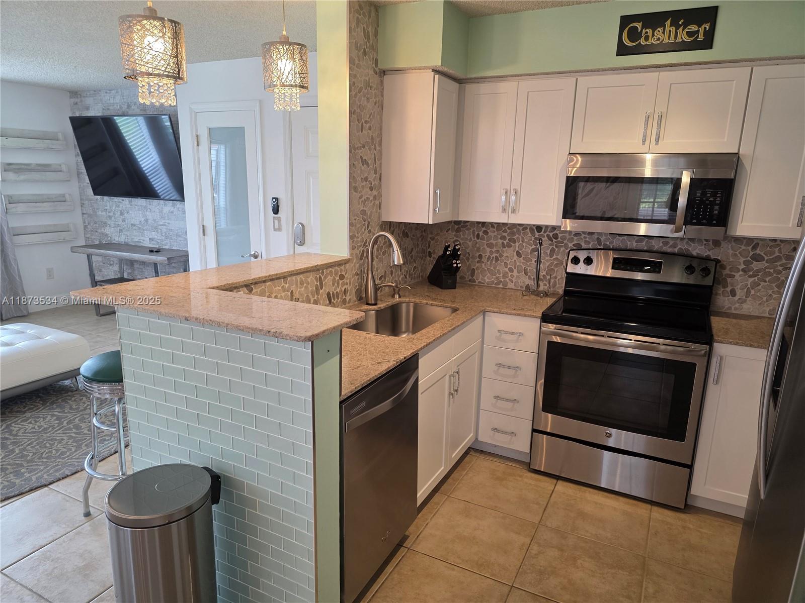 1365 Crystal Way, Unit G Delray Beach, FL 33444 - Photo 7 of 30 a kitchen with a sink stove and microwave