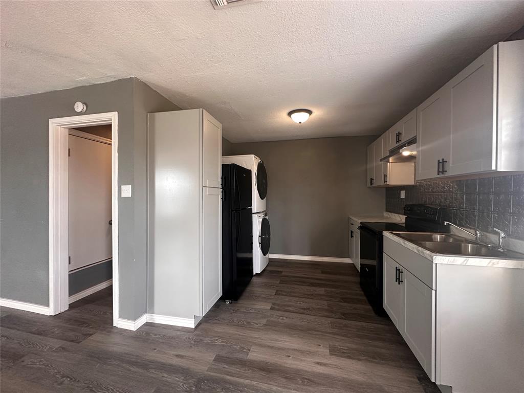 230 Bell Street Bangs, TX 76823 - Photo 2 of 7 a kitchen with a sink and a refrigerator