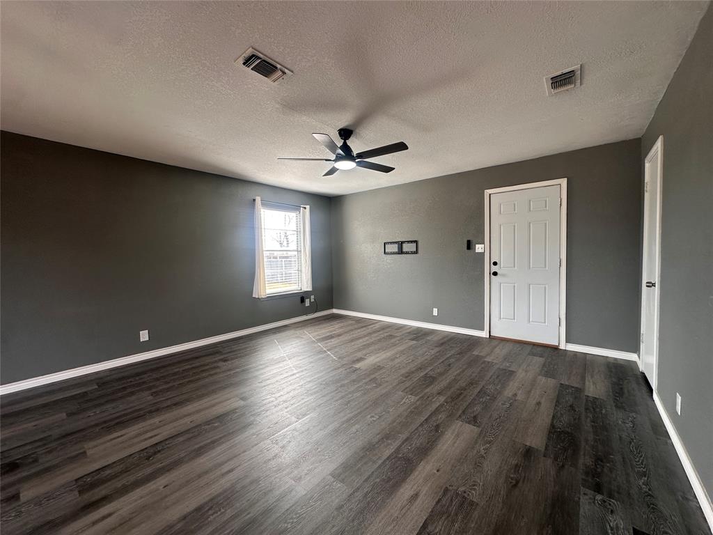 230 Bell Street Bangs, TX 76823 - Photo 4 of 7 wooden floor in an empty room with a window