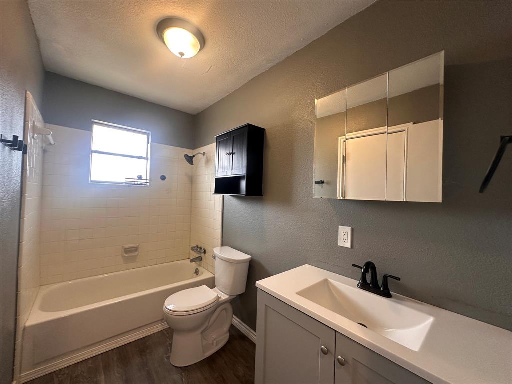 230 Bell Street Bangs, TX 76823 - Photo 5 of 7 a bathroom with a toilet sink and mirror