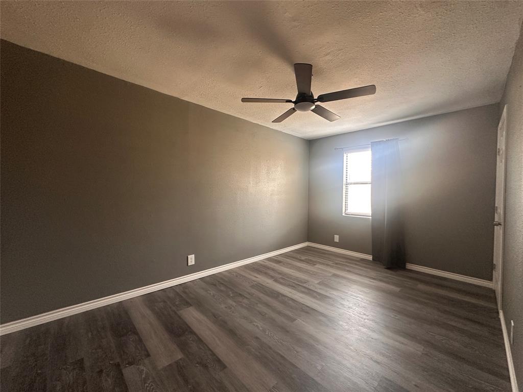 230 Bell Street Bangs, TX 76823 - Photo 6 of 7 a view of an empty room with window and wooden floor