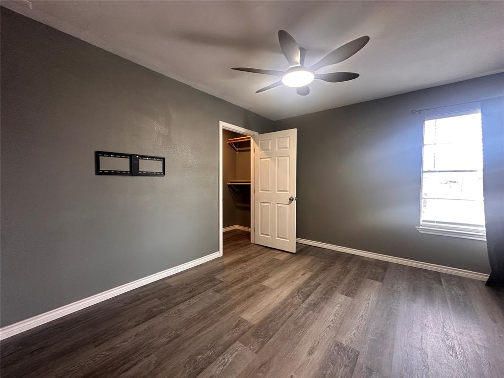 230 Bell Street Bangs, TX 76823 - Photo 7 of 7 a view of an empty room with window and wooden floor