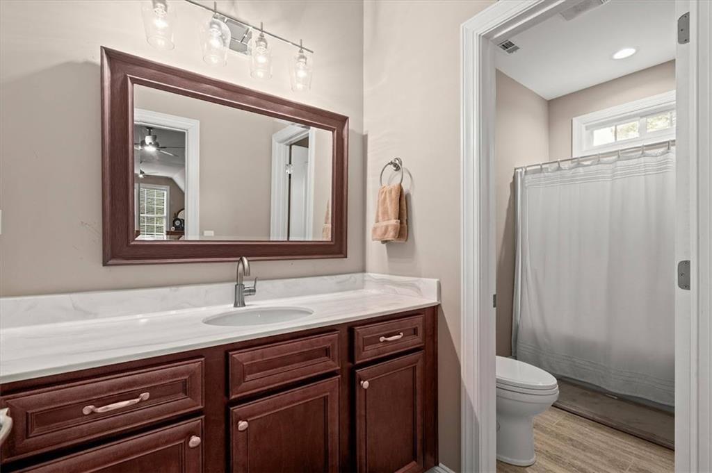 5320 North Helton Road Winston, GA 30187 - Photo 34 of 100 a bathroom with a toilet a sink a mirror and a shower